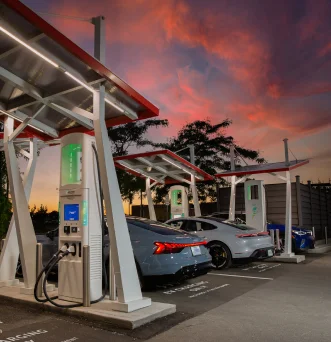 Electrify Canada charging stations at dusk with 3 EV vehicles charging